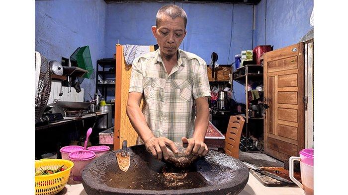 RUJAK TERKENAL SIAK - Amin Syahri pedagang rujak di Siak mengulek bumbu rujak di warungnya beberapa waktu lalu.