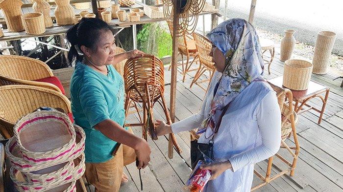 Pemilik usaha rotan Maju Bersama di Jalan Yos Sudarso Pekanbaru, Timeria berkomunikasi dengan salah satu pembelinya, Senin (22/4/2024). Timeria mengaku terbantu dengan bantuan kredit Ultra Mikro dalammengembangkan usahanya.