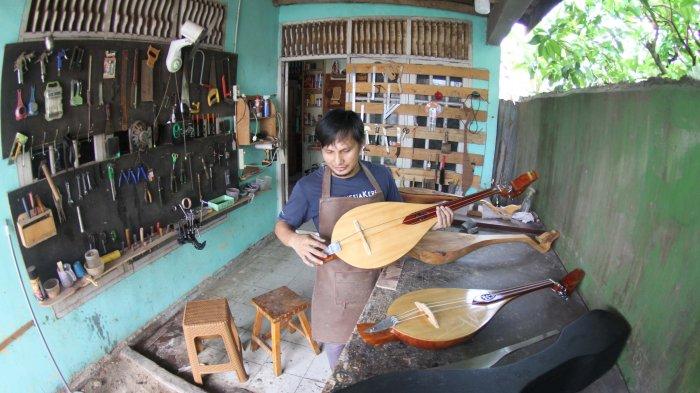 Pengrajin alat musik gambus Melayu, Robithah Irawan (34) tengah bekerja di workshop nya Jalan Kartama Pekanbaru, Jumat (9/8/2024).