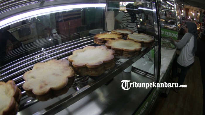 Pembuat Bolu Kemojo di Pasar Bawah Pekanbaru tengah mempersiapkan dagangannya, Jumat (27/7/2018). Seiring perkembangan, makanan khas melayu dari Riau yang awalnya hanya dibuat dengan rasa pandan ini, kini memiliki banyak varian rasa, diantaranya rasa durian, coklat, pisang, jagung dan lainnya. Modifikasi pada rasa ini dilakukan agar kue tradisional tersebut tidak ketinggalan zaman dan para pelanggan memiliki banyak pilihan sehingga bisa dinikmati banyak orang. TRIBUN PEKANBARU/THEO RIZKY