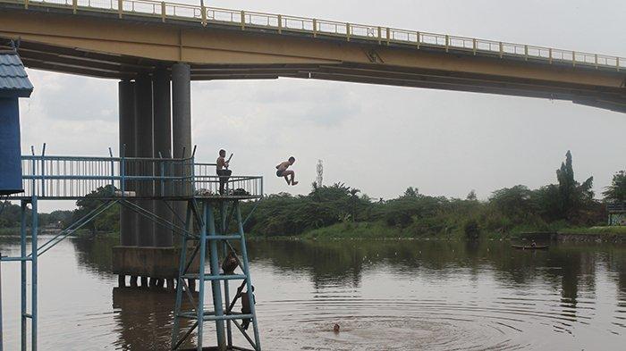 Anak-anak bermain di dekat sungai kecil