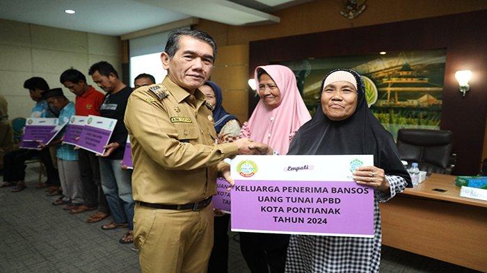 Pj Wali Kota Pontianak Ani Sofian menyerahkan bantuan sosial secara simbolis kepada warga penerima manfaat usai kegiatan Forum Konsultasi Publik Dinas Sosial dan Sosialisasi Penyaluran Bantuan Sosial Uang Tunai, di Ruang Rapat Kantor Wali Kota, Senin 10 Juni 2024.
