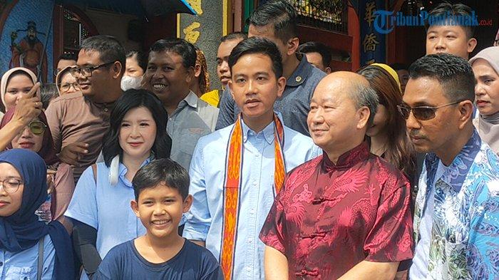 Cawapres nomor urut 2, Gibran Rakabuming Raka saat berfoto bersama masyarakat-masyarakat di Depan Pekong Pusat Kota atau Vihara Tri Dharma Bumi Raya Kota Singkawang, Kalimantan Barat, Minggu 17 Desember 2023. Gibran terlihat mengenakan pakaian berwarna biru. Terlihat juga Wakil Ketua Dewan Pembina PSI, Grace Natalie mendampingi.