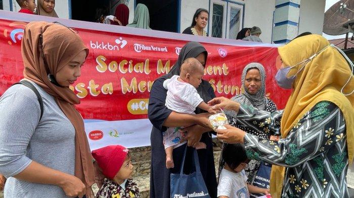 Heriyani Kasi Kesra Desa Telok Kapuas membagikan kado kepada anak-anak yang dinyatakan sudah tak stunting lagi di Poskesdes Teluk Kapuas Kabupaten Kubu Raya, Kamis 19 Oktober 2023.