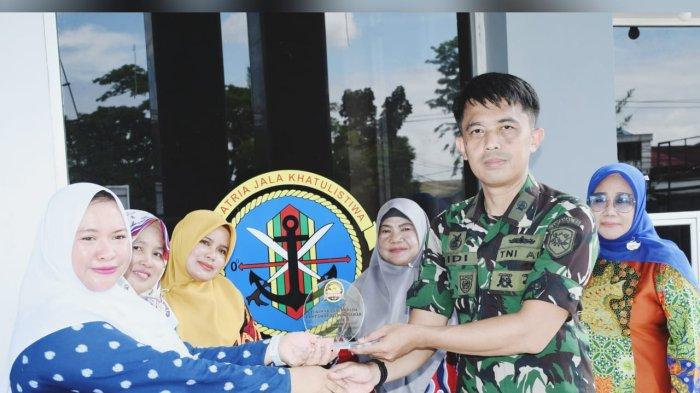 Kepala Sekolah Paud Bina Kasih, Sri Wahyuni menyerahkan cinderamata kepada Letda Laut, Didi Kurniansyah.