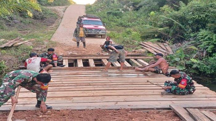 Masyarakat dua desa yaitu Desa Miau Merah dan Desa Bukit Penai, Kecamatan Silat Hilir, bersama anggota TNI AD bertugas di Koramil, saat bergotong royong untuk memperbaiki jembatan penghubung dua desa tersebut, yang mengalami kerusakan parah, Sabtu 11 Mei 2024.