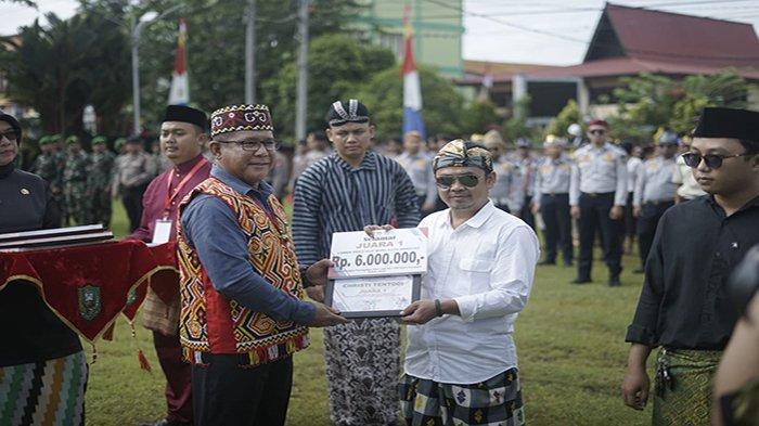 Pj Bupati Sanggau Suherman saat menyerahkan hadiah secara simbolis kepada Christi Tentodi pemenang lomba pembuatan video klip lagu mars kota Sanggau di halaman Kantor Bupati Sanggau, Kalimantan Barat, kemarin.