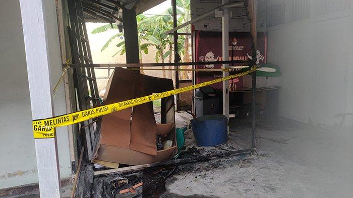 Polisi Polsek Sambas memasang garis polisi di area kejadian merembetnya api yang nyaris melanda Kantor KPU Sambas, Minggu 19 Mei 2024.