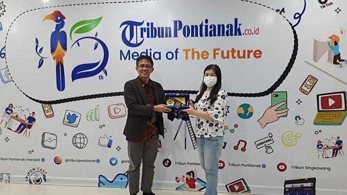Rektor UPB Pontianak Purwanto memberikan cinderamata kepada GM Business Tribun Pontianak Julia Lorrains saat berkunjung ke kantor Harin Tribun Pontianak, Jumat (23/2).