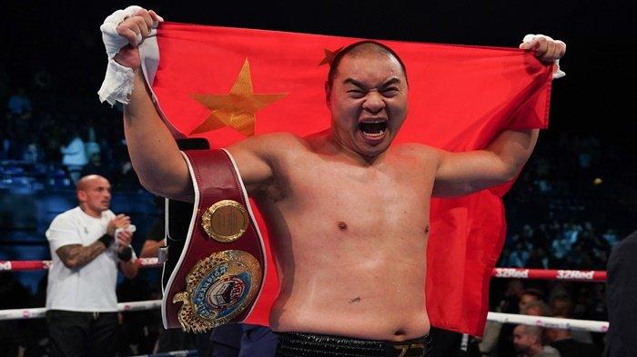 Zhilei Zhang berselebrasi dengan bendera China dan sabuk WBO Interim usai mengalahkan Joe Joyce Minggu 24 September 2023