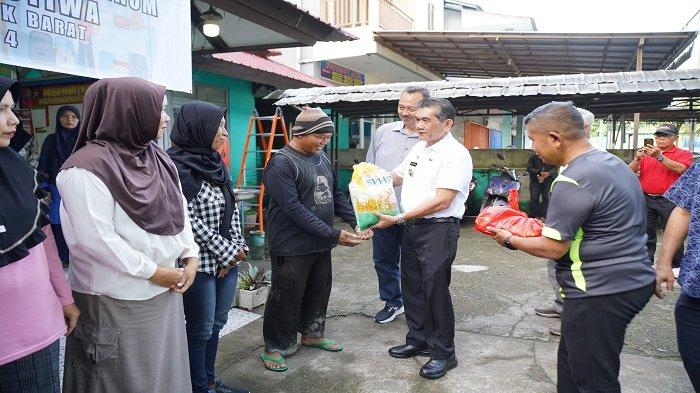 PJ Wali Kota Pontianak Ani Sofian menyerahkan secara simbolis paket sembako yang dibeli warga di kelurahan-kelurahan se-Kecamatan Pontianak Barat, Minggu 3 Maret 2024.