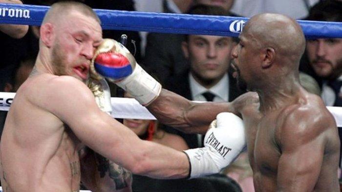 Floyd Mayweather Jr melepaskan pukulan ke arah wajah Conor McGregor pada pertarungan yang bertajuk The Money Fight yang digelar di T-Mobile Arena, Paradise, Nevada, Amerika Serikat, 26 Agustus 2017.