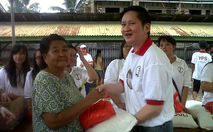 Anggota Pembina YPS, Henoch Thomas memberikan paket sembako kepada satu di antara warga Siantan Tengah di SD Kanisius, Sabtu (7/12/2013).