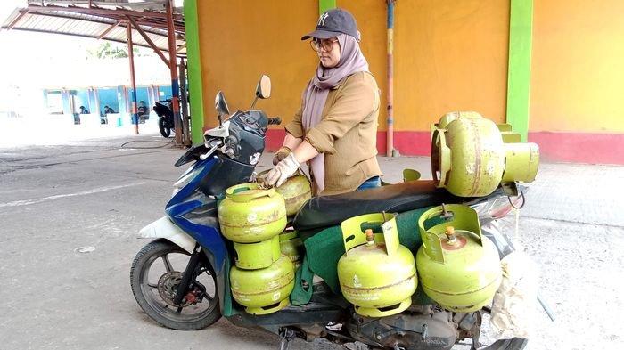 Hanifah menenteng 10 tabung elpiji 3 kilogram sekali antar dengan menggunakan sepeda motor.