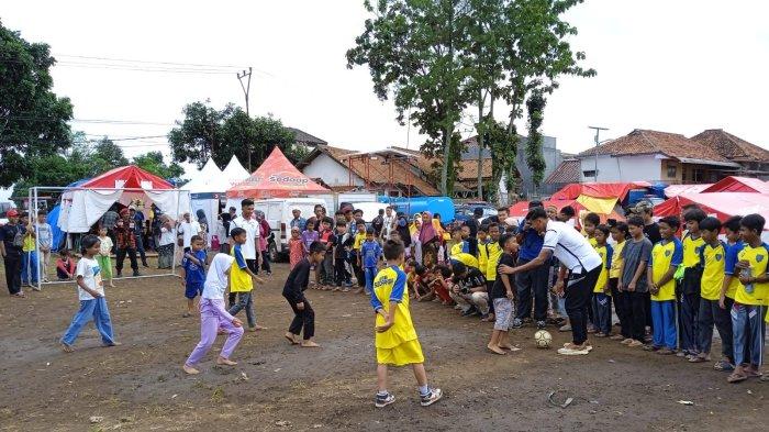 Kakang Rudianto (baju kanan putih) bersama anak-anak koban gempa Cianjur bermain sepak bola di Lapang Jagaraksa, Desa Jambudipa, Kecamatan Warungkondang, Kabupaten Cianjur, Jumat (2/11/2022).
