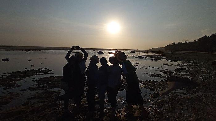 Sejumlah wisatawan nampak asyik berfoto dengan latar matahari terbenam di Pantai Minajaya, Sukabumi. 