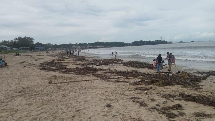 Tumpukan sampah kayu terlihat di pesisir Pantai Santolo, Kabupaten Garut, Jawa Barat, Senin (27/1/2025). Sampah tersebut diketahui kiriman dari sungai-sungai di kawasan selatan Garut setelah terjadi luapan Minggu malam.