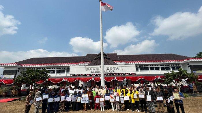 Warga Kota Tasikmalaya berprestasi berfoto bersama dengan penjabat Wali Kota Tasikmalaya dan jajaran pada upacara peringatan HUT ke-22 Kota Tasikmalaya di lapangan Bale Kota Tasikmalaya, Selasa (17/10/2023).