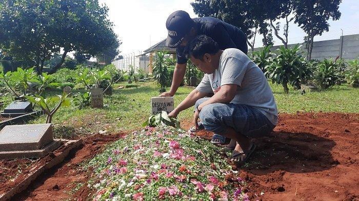 Saimun (kiri) berdoa di makam anaknya Desi Yulianty usai kegiatan pemakaman di Taman Pemakaman Pule, Rawadenok, Pancoran Mas, Kota Depok, Jawa Barat, pada Minggu (12/5/2024).