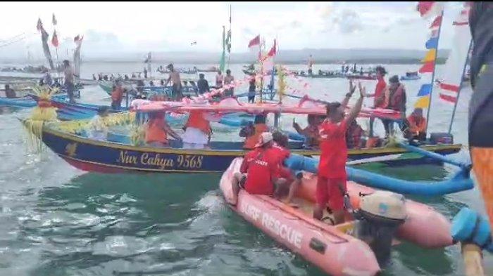 Saat berlangsungnya tabur bunga tradisi hajat laut dan suasana disaat satu perahu nelayan tergulung ombak