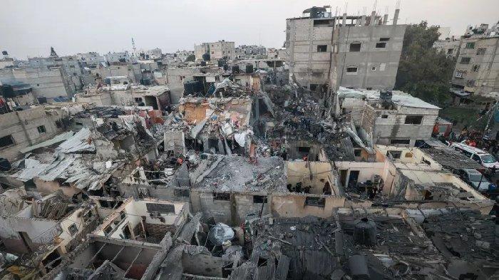 Warga Palestina memeriksa kehancuran setelah pemboman Israel di Rafah, bagian selatan Jalur Gaza, pada 12 Desember