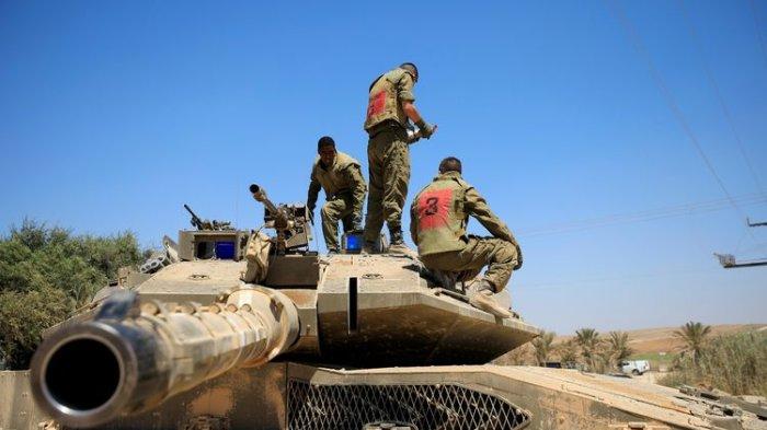 Para tentara Israel berdiri di atas tank, yang ditempatkan di dekat perbatasan antara Israel dengan Jalur Gaza, pada Minggu (16/8/2020).(REUTERS/AMIR COHEN)