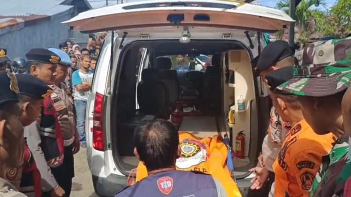 Petugas dari pihak kepolisian dan warga melakukan evakuasi terhadap jenazah 1