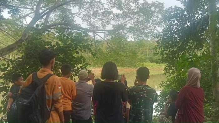 Warga menyaksikan buaya liar yang sedang berjemur di bantaran Sungai Krueng Meureubo