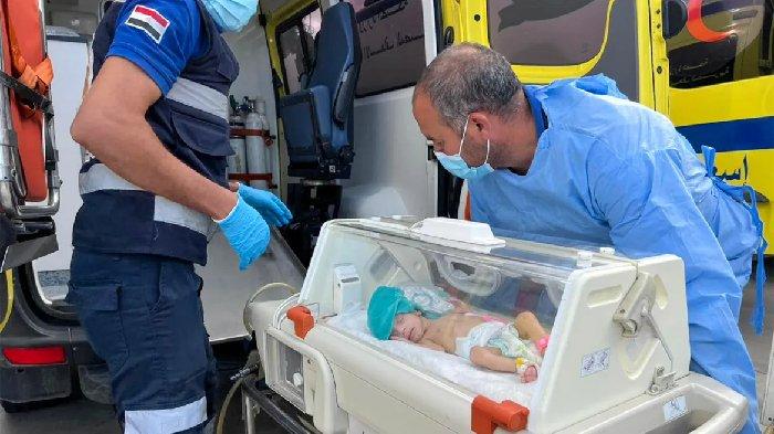 Petugas medis Mesir mendorong bayi prematur Palestina yang dievakuasi dari Gaza ke ambulans di perbatasan Rafah sisi Mesir.