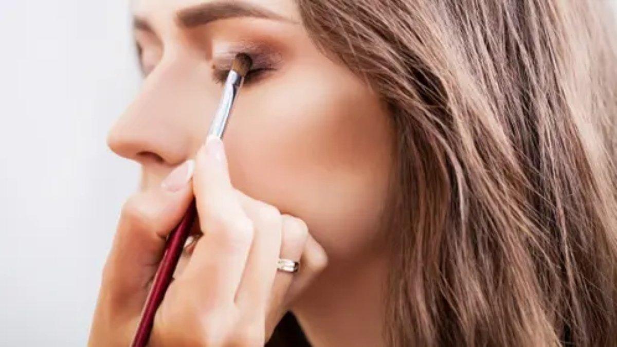 Ilustrasi wanita menggunakan eyeshadow.