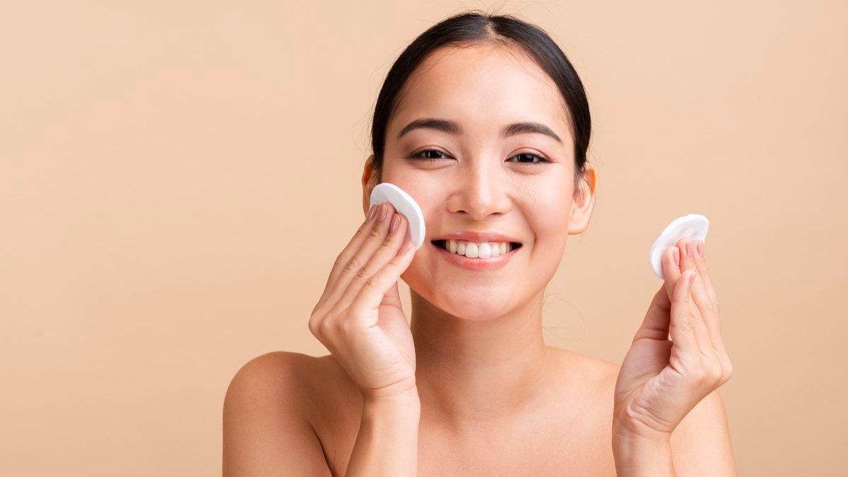 Ilustrasi wanita membersihkan wajah menggunakan micellar water.