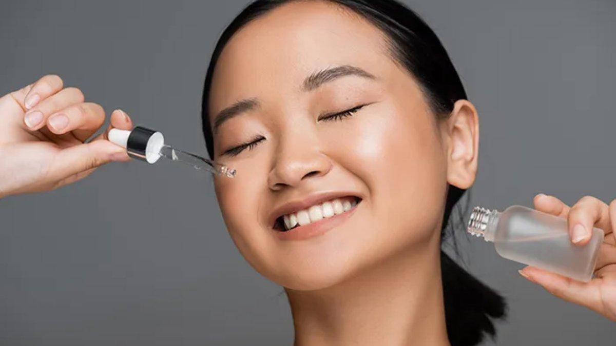 Ilustrasi wanita menggunakan serum pencerah.