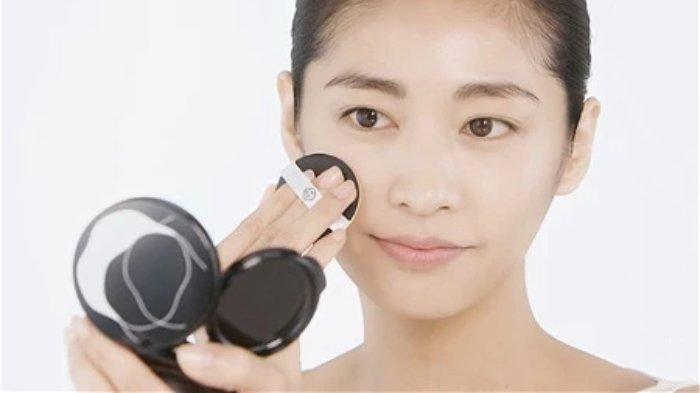 Ilustrasi wanita menepuk-nepuk cushion agar hasilnya tahan lama saat cuaca panas.