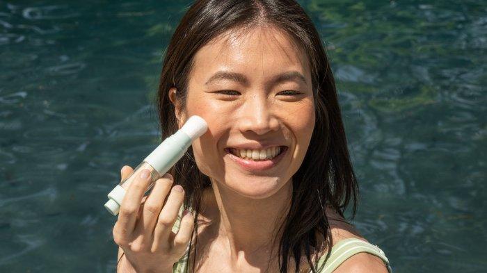 Ilustrasi wanita menggunakan sunscreen.