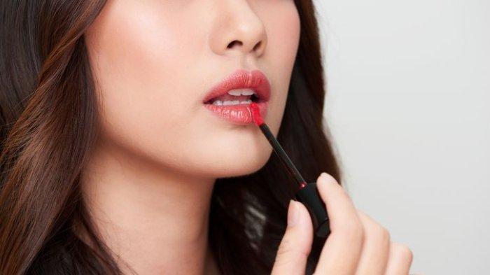 Ilustrasi mengaplikasikan lip tint dengan kandungan terbaik.