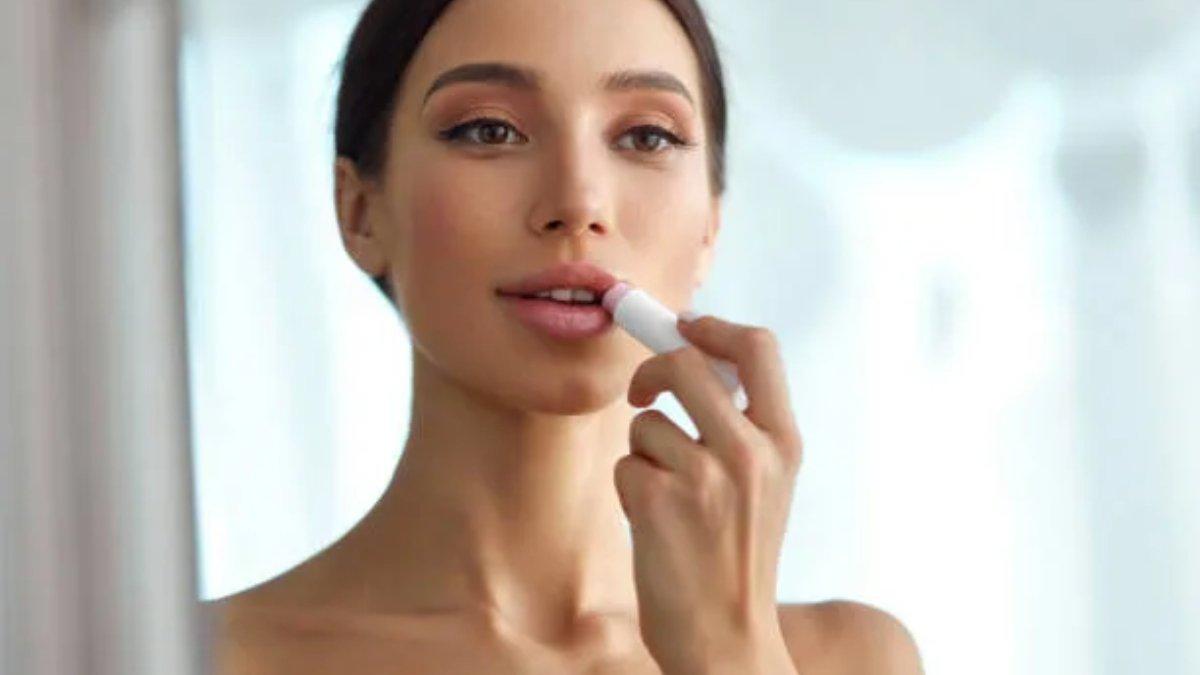 Ilustrasi wanita menggunakan lip balm.