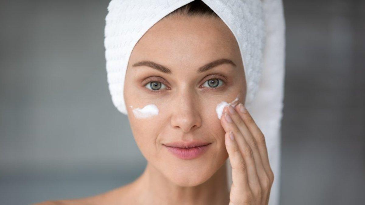 Ilustrasi wanita mengoleskan sunscreen pada wajah