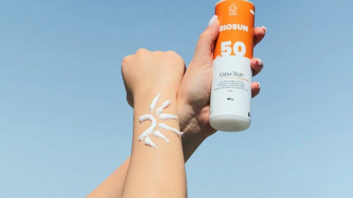 Ilustrasi wanita menggunakan sunscreen pada badan.