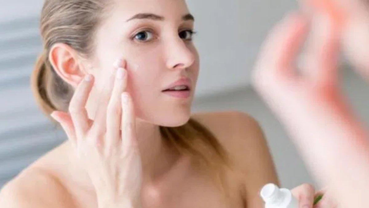 Ilustrasi wanita mengaplikasikan skincare yang mengandung bakuchiol.