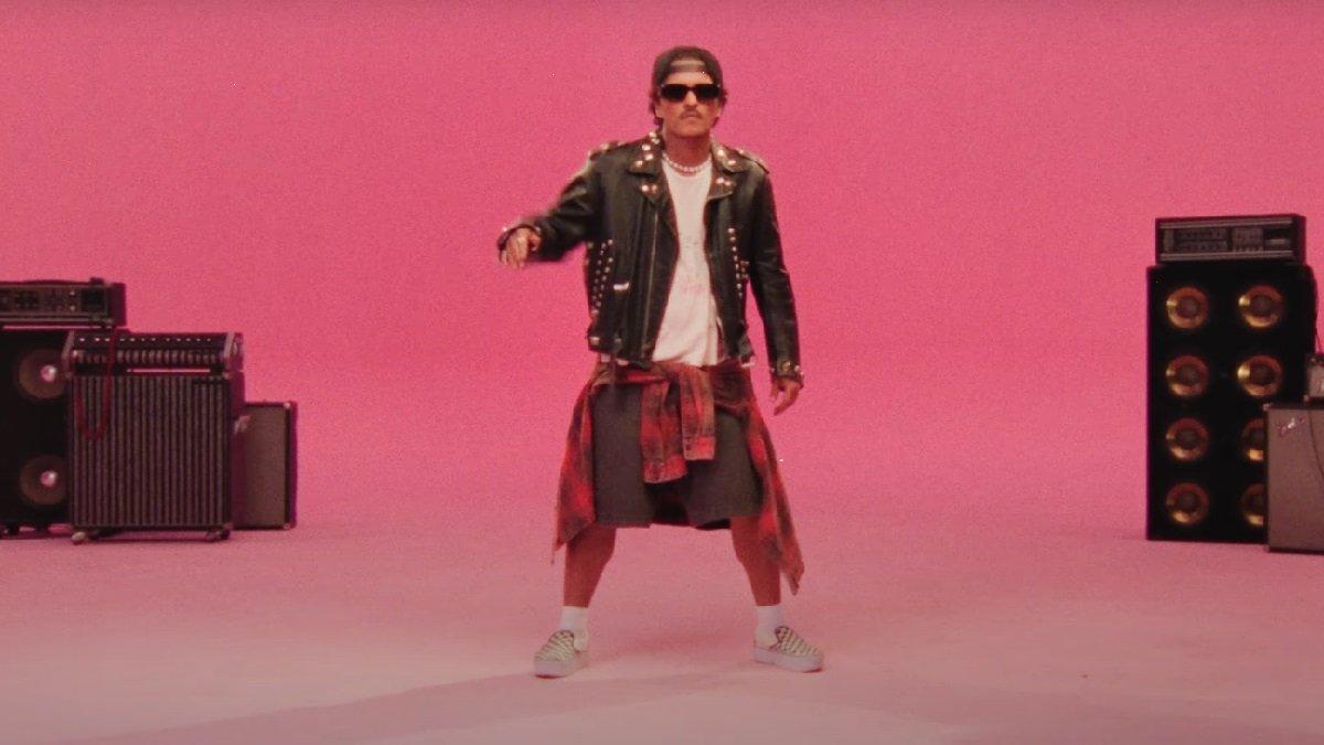 Bruno Mars memadukan kaos putih dan celana pendek dengan jaket kulit serta kemeja flanel merah yang diikat di pinggangnya.