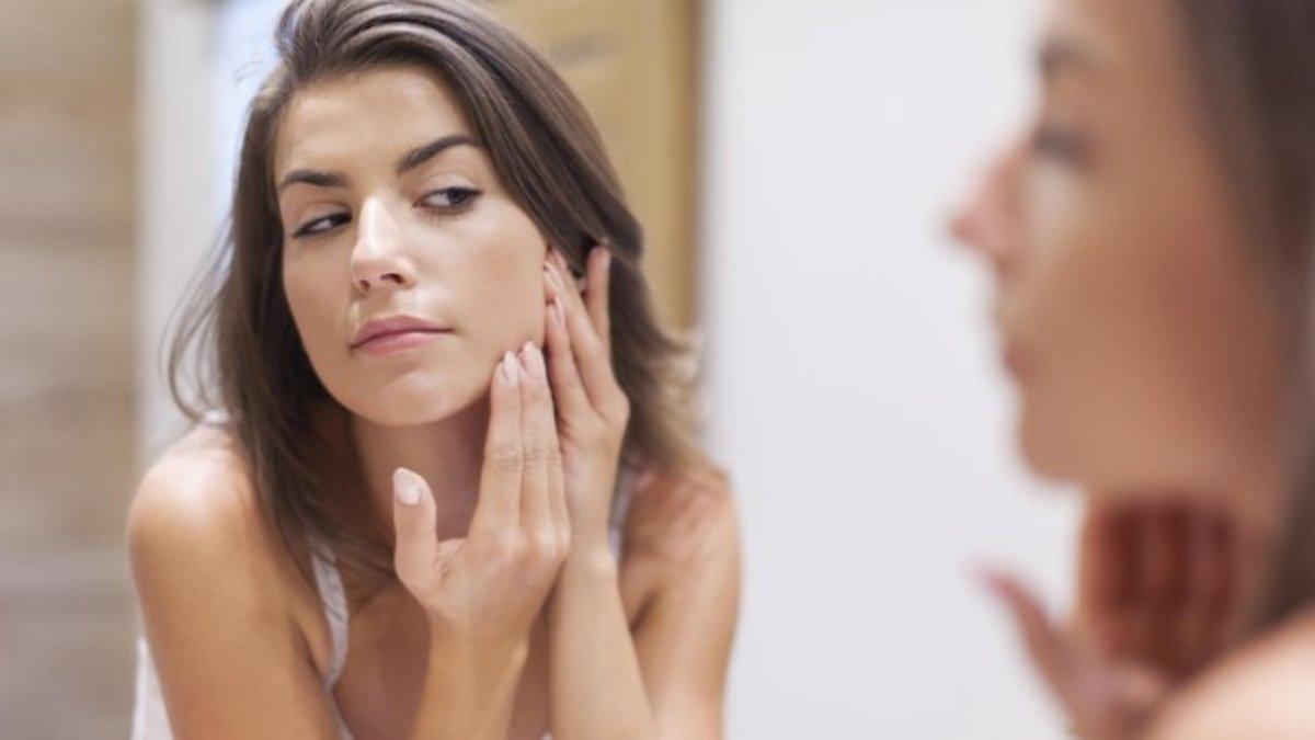 Ilsutrasi wanita menyentuh wajah setelah menggunakan setting spray.