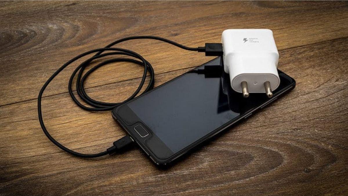 Ilustrasi melepas charger dari stopkontak setelah daya baterai kembali penuh