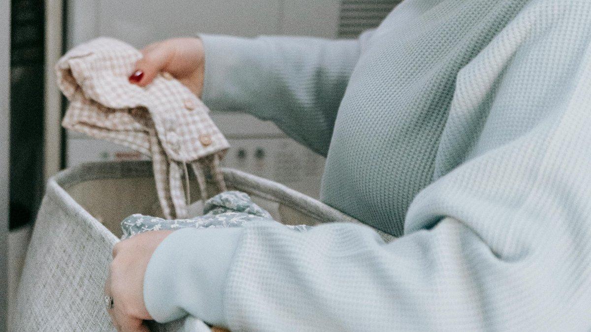 Ilustrasi Memperhatikan Bahan Baju Bayi.