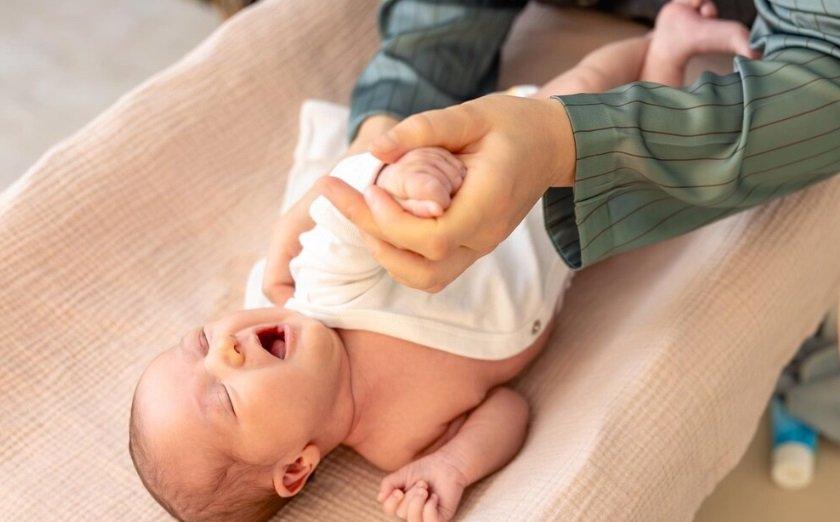 Ilustrasi bayi memakai baju tipis saat demam setelah imunisasi
