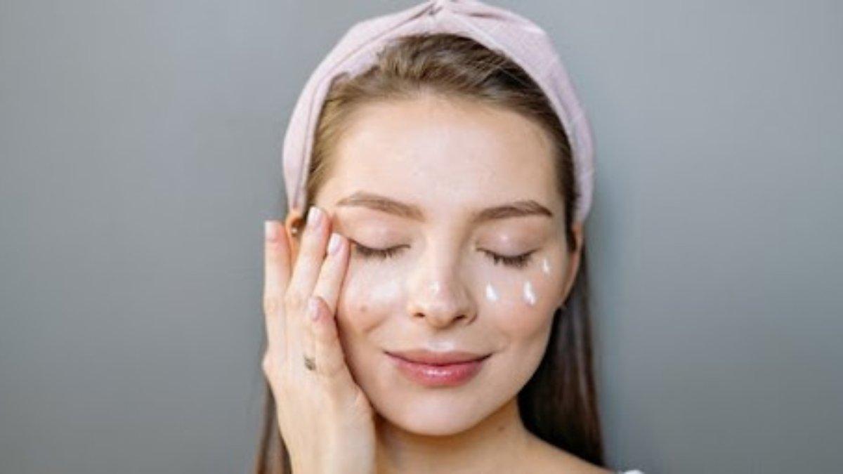 Ilustrasi memijat area mata dengan lembut saat menggunakan eye cream.