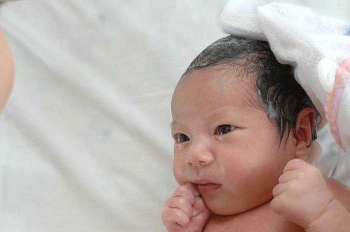 Ilustrasi mencuci rambut pada bayi yang memiliki kerak di kepala