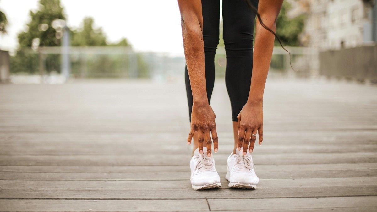 Ilustrasi Seorang Wanita Pemanasan Sebelum Jogging Menggunakan Sepatu Running
