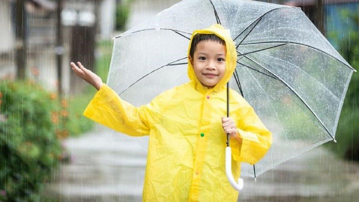 Ilustrasi si kecil menggunakan hoodie dan jas hujan poncho saat hujan.