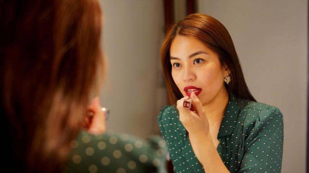 Ilustrasi wanita mengoleskan lip tint ke seluruh bibir secara merata.