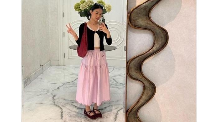 Ilustrasi tren fashion coquette dengan padu padan rok dan cardigan hitam.